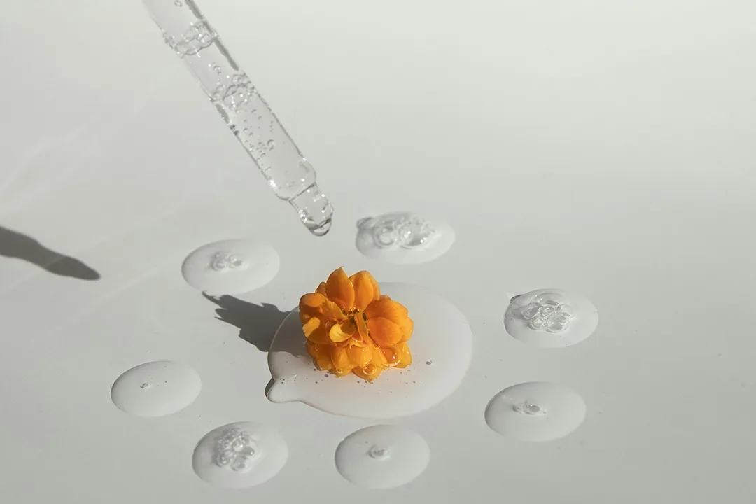 A tincture of water with droplets forming a ring around a dried flower